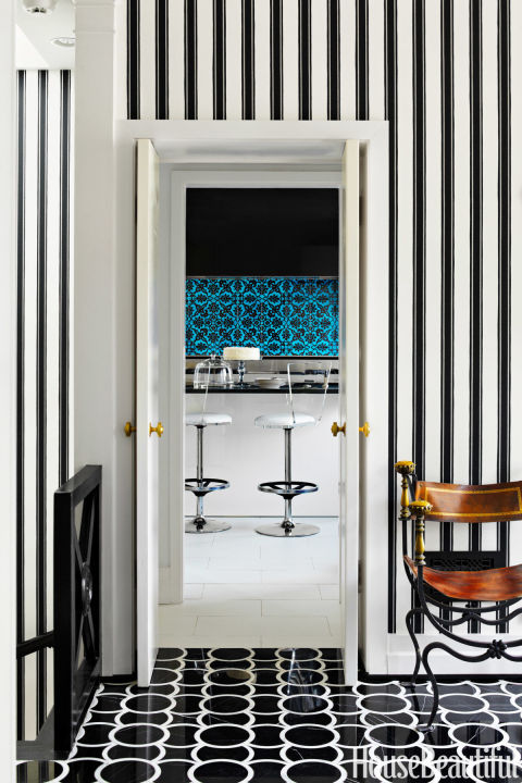 Graphic patterns extend from the foyer in a Washington, D.C. town house through to the kitchen. "We both like snappy architectural solutions — like the patterned floor and striped wallpaper — that give black-tie panache to small spaces," designer Jeff Lincoln says of the house he designed with Hillary Thomas. The black and white of Montgomery 1 marble floor tiles by Ann Sacks and Block Print Stripe wallpaper by Farrow & Ball is reminiscent of Dorothy Draper.
