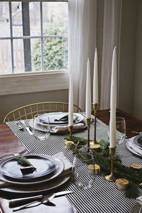 Green pine branches stand out in the most festive way when paired with black and white. And don't even get us started on how much we love the Scandinavian touch of the brass candlesticks. See more at Annabode + Co. »