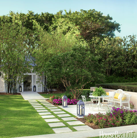 A dining pavilion flanked with flowers anchors the backyard of a Florida home.<br />