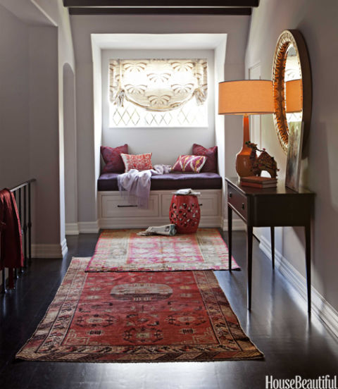 In the second-floor hallway of a California house, designer Betsy Burnham overlaps Turkish runners from Rugs & Art, drawing the eye to a Moroccan-inspired reading nook. The vintage carpets "can transform a plain hallway into a decorated space," Burnham says. "A really faded, tattered rug is instantly Bohemian." The window seat is covered in Tibet woven silk from S. Harris. Pillows by Hollywood at Home; garden stool from Rolling Greens. 