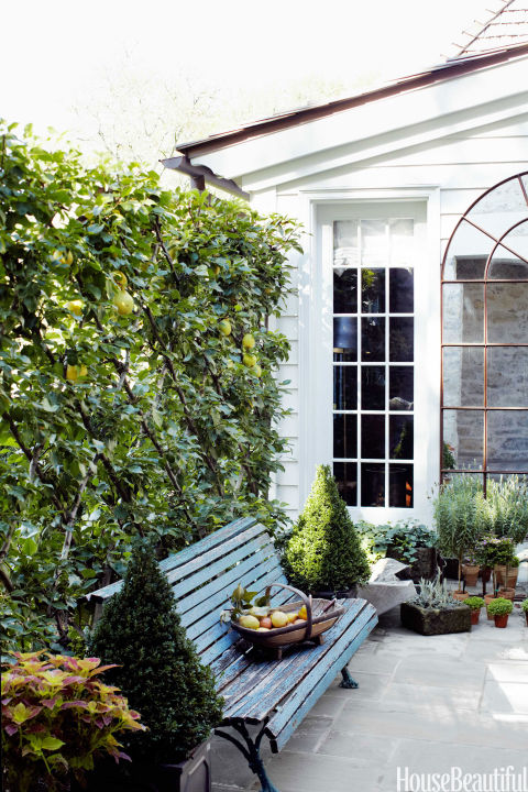 A Southern-inspired secret garden is enclosed by pear trees espaliered on a trellis.<br />