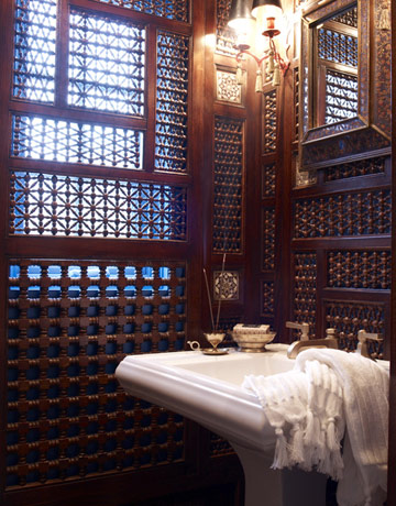 Designer Laura Kirar adapted antique Moroccan fretwork panels to transform a dark leftover space below a stairway into an alluring Orientalist jewel box.
